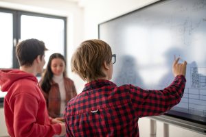 Des lycéens au tableau de leur salle de classe