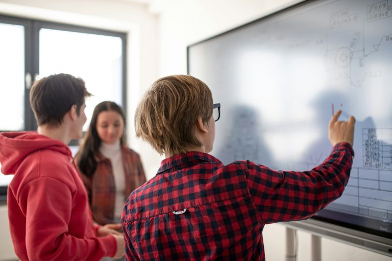 Des lycéens au tableau de leur salle de classe